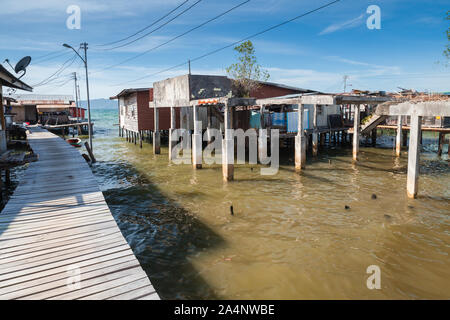 Vista del quartiere povero di Kota Kinabalu, Malaysia. Vecchie case in legno e passerelle su palafitte Foto Stock