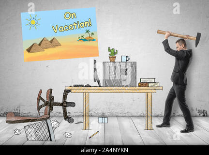Imprenditore smashing il suo posto di lavoro con un martello Foto Stock