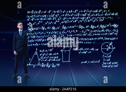 Uomo in un vestito a piena altezza molto di scrittura di formule trigonometrical in aria Foto Stock