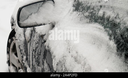 Specchietto laterale coperto di neve durante il giorno d'inverno. Foto Stock