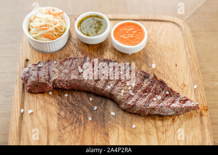 Hot intero grigliato bistecca di Denver con Cavolo sott'aceto e due salse. Servire su una tavola di legno. Ristorante Barbecue menu. una serie di foto di Foto Stock