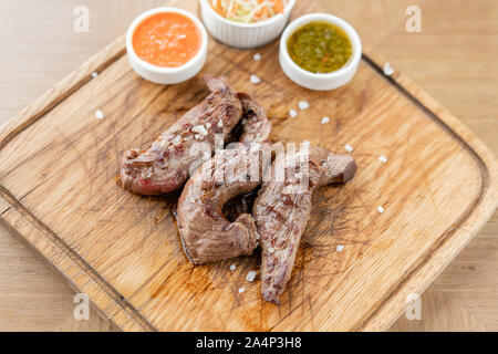 Il filetto di agnello con Cavolo sott'aceto e due salse. Servire su una tavola di legno. Ristorante Barbecue menu, una serie di foto di tipi diversi di carne. Foto Stock