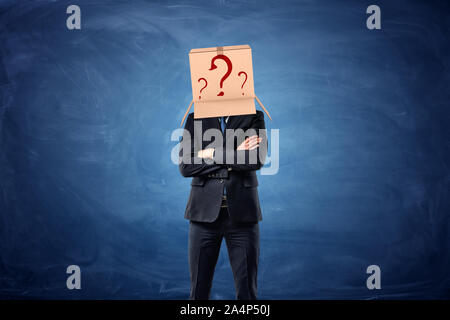 Imprenditore si usura in scatola di cartone con disegnato un punto interrogativo sulla sua testa Foto Stock