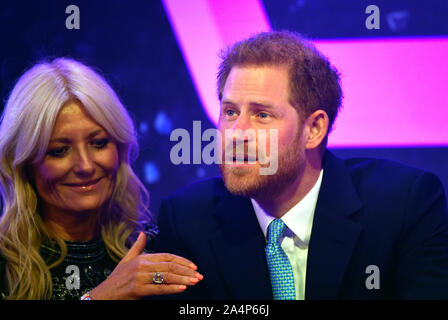 Il Duca di Sussex reagisce accanto al presentatore televisivo Gaby Roslin come egli offre un discorso durante l annuale WellChild premi al Royal Lancaster Hotel di Londra. Foto Stock