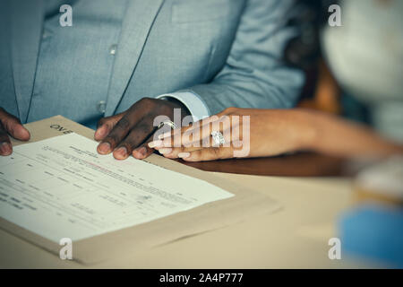 Motswana giovane sposarsi tenendo le mani nella parte anteriore del loro certificato di matrimonio Foto Stock