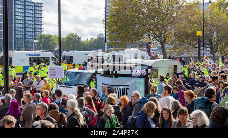 Millbank, London, Regno Unito 15 ottobre 2019; una folla di estinzione della ribellione gli attivisti con un pesante prescence di polizia dietro Foto Stock