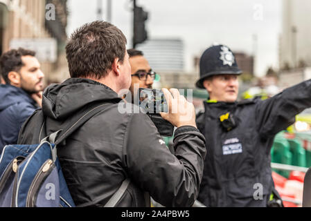 Bianco maschio caucasico di filmare un funzionario di polizia fermare lui di avvicinarsi al Parlamento prima della apertura della condizione del Parlamento Foto Stock