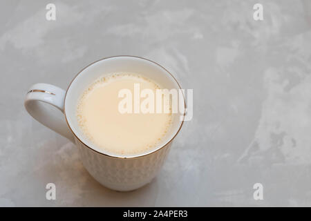 Tè nero con latte e spezie (masala tea) in ceramica bianca cup su sfondo grigio Foto Stock