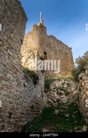 Vista di Palafolls medievale castello rovinato fortezza tra Girona e Barcellona in Costa Brava con la bandiera catalana orgogliosamente volando sopra la Roma Foto Stock