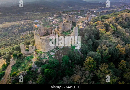 Vista di Palafolls medievale castello rovinato fortezza tra Girona e Barcellona in Costa Brava con la bandiera catalana orgogliosamente volando sopra la Roma Foto Stock