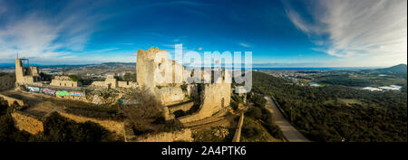 Vista di Palafolls medievale castello rovinato fortezza tra Girona e Barcellona in Costa Brava con la bandiera catalana orgogliosamente volando sopra la Roma Foto Stock