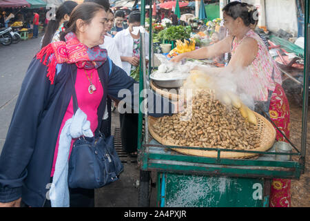 Mae Sot, Tailandia - 3 Maggio 2019: i clienti circa i fornitori di una bancarella vendendo i dadi. Il mercato di mattina è aperto ogni giorno. Foto Stock