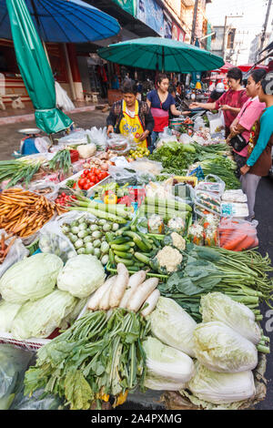 Mae Sot, Tailandia - 3 Maggio 2019: i clienti circa i fornitori di una bancarella vendendo verdure. Il mercato di mattina è aperto ogni giorno. Foto Stock