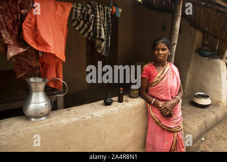 Una donna dalla Santal comunità sorge di fronte a casa sua, in Joypurhat, Rajshahi, Bangladesh. Maggio 20, 2011. .L'Santals sono una minoranza etnica a vivere in una comunità in diversi distretti di Rajshahi divisione in Bangladesh. La maggior parte non proprio a terra e il lavoro come tutti i giorni pagati operai per retribuzioni molto basse. Gran parte dei miglioramenti apportati in termini di tecnologia hanno bypassato queste comunità isolate dove dominano i maschi e le donne sostenere il fardello di agricoltura e di effettuare altri mezzi di sussistenza.Santals sono anche il gruppo etnico in India dove hanno insediamenti negli stati di Jharkhand, West Bengal, Bi Foto Stock