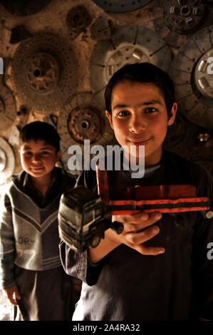 Due ragazzi afghani a un workshop di automobile, nel nord-ovest della città di Herat, Afghanistan. Il 6 maggio 2009. I ragazzi che si uniscono come 'shagrid' (allievo) all'sweatshops guadagna circa 300 Afghana (6 U.S. Di dollari) a settimana. Foto Stock