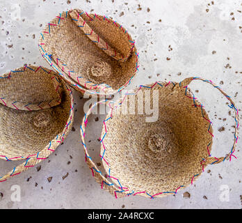 Tre di vimini cesti di paglia sostare sul marciapiede. Foto Stock