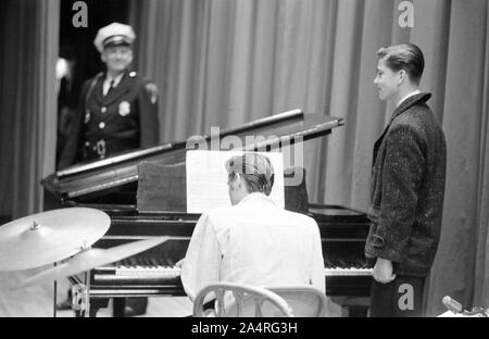 Elvis Presley in attesa di uno show per avviare, suonare il pianoforte, presso la University of Dayton Fieldhouse, 27 maggio, 1956. Foto Stock
