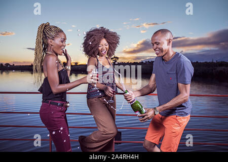 Persone popping champagne su Sakkie se Arkie Sunset cruise Foto Stock