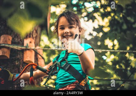 Bambina nel parco avventura in estate Foto Stock