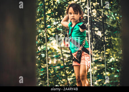 Bambina nel parco avventura in estate Foto Stock