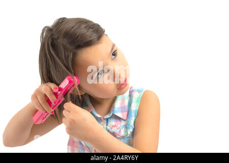 Piccola ragazza con i capelli facendo i suoi capelli Foto Stock