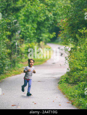 Bambino in esecuzione su strada Foto Stock