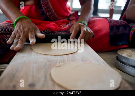 Al di sopra di vista della giovane donna indiana rendendo freschi fatti in casa e rotis chapati, un classico indiano cibo di strada Foto Stock