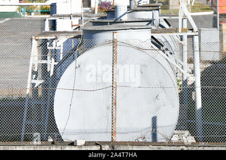 Vecchio arrugginito serbatoi carburante in cantiere. Cancellare soleggiata giornata estiva abbandonato vecchi serbatoi. Foto Stock