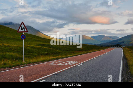 Strada tortuosa segno sulla strada attraverso il maestoso Highlands scozzesi, Scozia Foto Stock