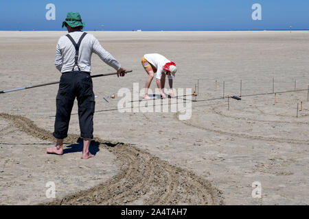 Creazione di disegni di sabbia in spiaggia in Olanda Foto Stock