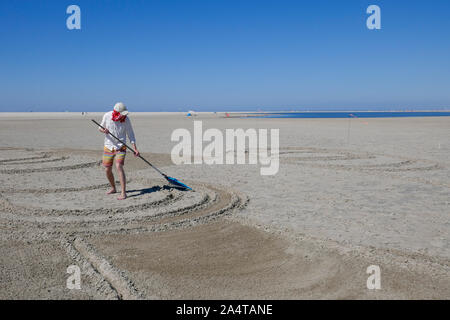 Creazione di disegni di sabbia in spiaggia in Olanda Foto Stock