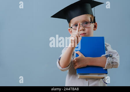 Redhead primo ragazzo livellatrice in bicchieri e studente con cappello di puntare il dito fino Foto Stock