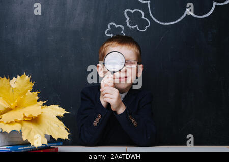 Little Boy allo zenzero che partecipano in tradizionale il primo giorno di scuola sessione fotografica Foto Stock