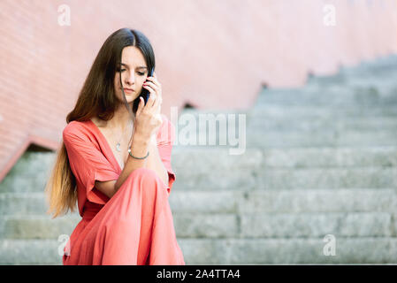 Preoccupato della donna parlando al telefono. Bad News concept Foto Stock