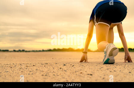 Atleta donna runner pronti per iniziare i corsi di formazione per eseguire presso il parco la mattina. Donna indossare scarpe da ginnastica per la gara. Femmina asiatica cardio esercizio Foto Stock
