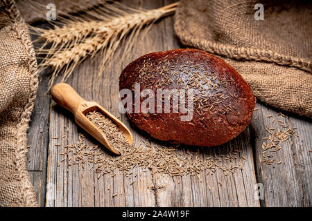 Pane di segale spikelets. Appena sfornato il pane tradizionale su un tavolo di legno. Foto Stock