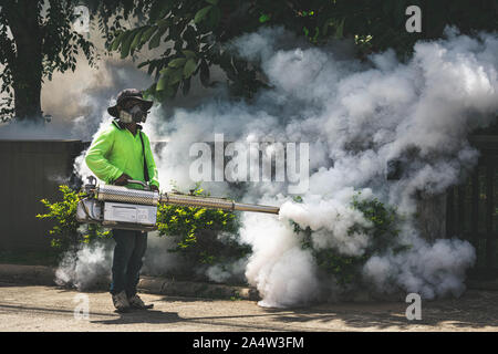 Uomo che utilizza fogger macchina a controllo da pericolose zanzare Foto Stock