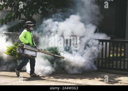 Uomo che utilizza fogger macchina a controllo da pericolose zanzare Foto Stock