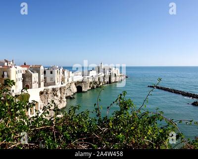 Edifici in pietra imbiancati con Chiesa di San Francesco, costruiti sul punto di una penisola, Vieste, Penisola del Gargano, Italia, Foto Stock