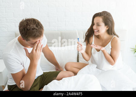 Giovane uomo è sconvolto quando donna bella mostra di lui al test di gravidanza Foto Stock