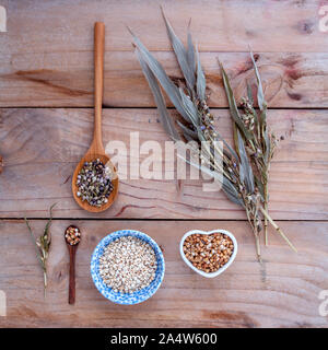 Cibo sano, organico insieme i grani di riso Miglio nella ciotola ,miglio bianco e il miglio di cob contro di legno rustico sfondo. Foto Stock