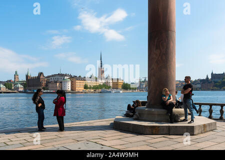 La città di Stoccolma, vista di persone in piedi sulla Stadshuset (Municipio) terrazza giardino con il Riddarholmen centro storico situato di fronte al porto. Foto Stock