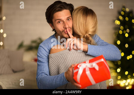 La shh marito dando regalo di Natale alla moglie Foto Stock