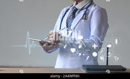 Donna medico tenendo premuto matita digitale e toccando lo schermo sul dispositivo smart con icona mediche Foto Stock