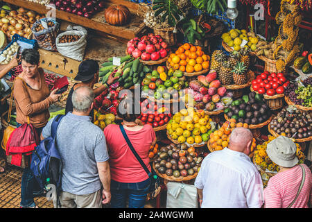 Funchal, Madeira, Portogallo - Sep 21, 2019: persone che acquistano la frutta e la verdura fresca sul mercato tradizionale Mercado dos Lavradores nel capitale di Madeira. Colorata frutta tropicale. Foto Stock