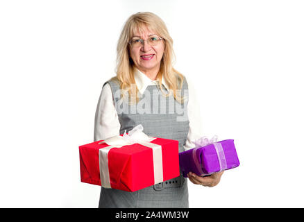 Senior donna con scatole di regali nelle sue mani su uno sfondo luminoso. Foto Stock