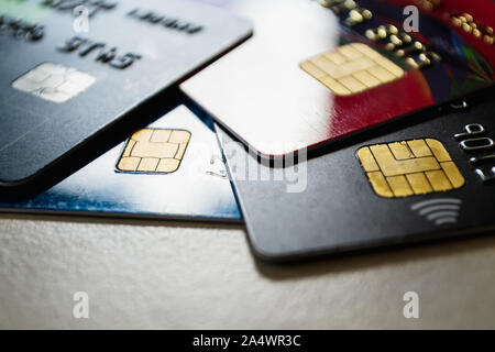 Alcuni di plastica carte di credito con chip contactless e pagare la tecnologia close-up. Tasto basso shot con vecchie carte di credito. Su un tavolo. Foto Stock