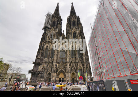 Colonia, agosto 2019. L'imponente facciata della cattedrale mostra il ponteggio per la manutenzione continua. Alla base di molti turisti. Foto Stock