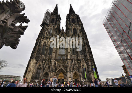 Colonia, agosto 2019. L'imponente facciata della cattedrale mostra il ponteggio per la manutenzione continua. Alla base di molti turisti. Foto Stock