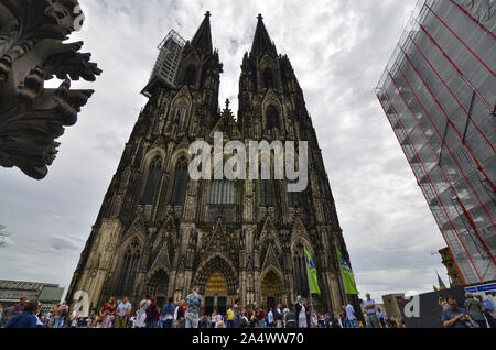 Colonia, agosto 2019. L'imponente facciata della cattedrale mostra il ponteggio per la manutenzione continua. Alla base di molti turisti. Foto Stock